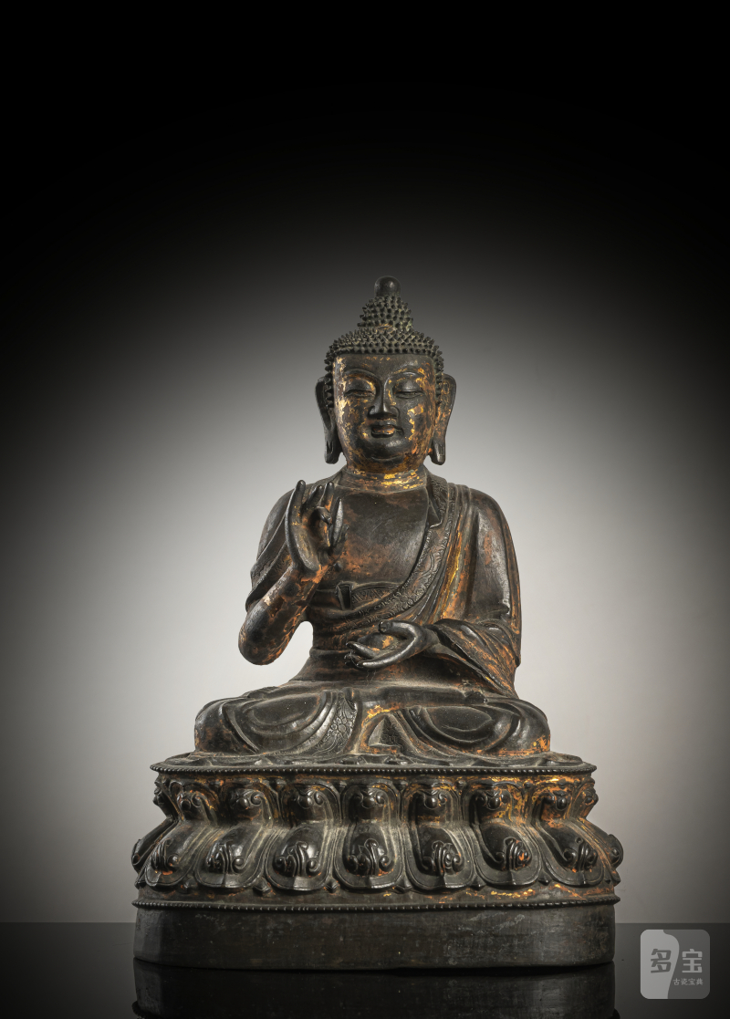 A bronze figure of Buddha Shakyamuni on a lotus throne with remnants of gilding